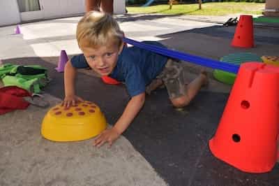 Boy crawling under limbo pole.